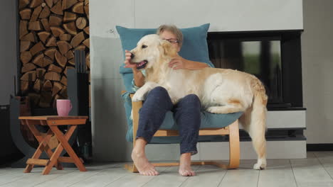 mujer acurrucada con un golden retriever en casa