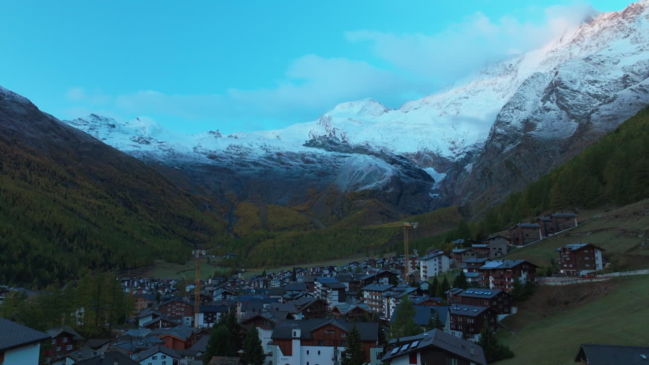 amanecer saas tarifa saastal suiza puente aéreo drone góndola metro alpino tranvía alpino suizo chalet valle montañas mañana glaciar feevispa río amarillo naranja otoño alerce grúa hacia arriba