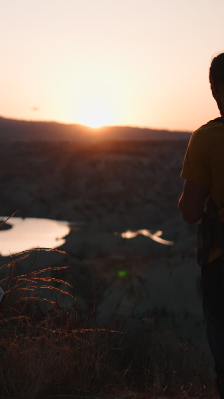Uomo che fa volare un drone al tramonto
