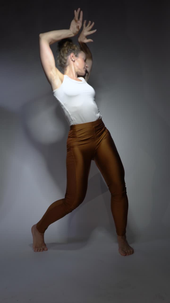 Energetic dancer performing creative and emotive poses with focused expression against neutral studio backdrop