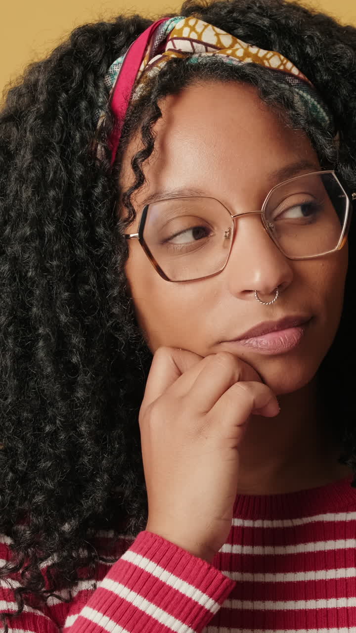 Young Woman with Curly Hair and Glasses Thinking