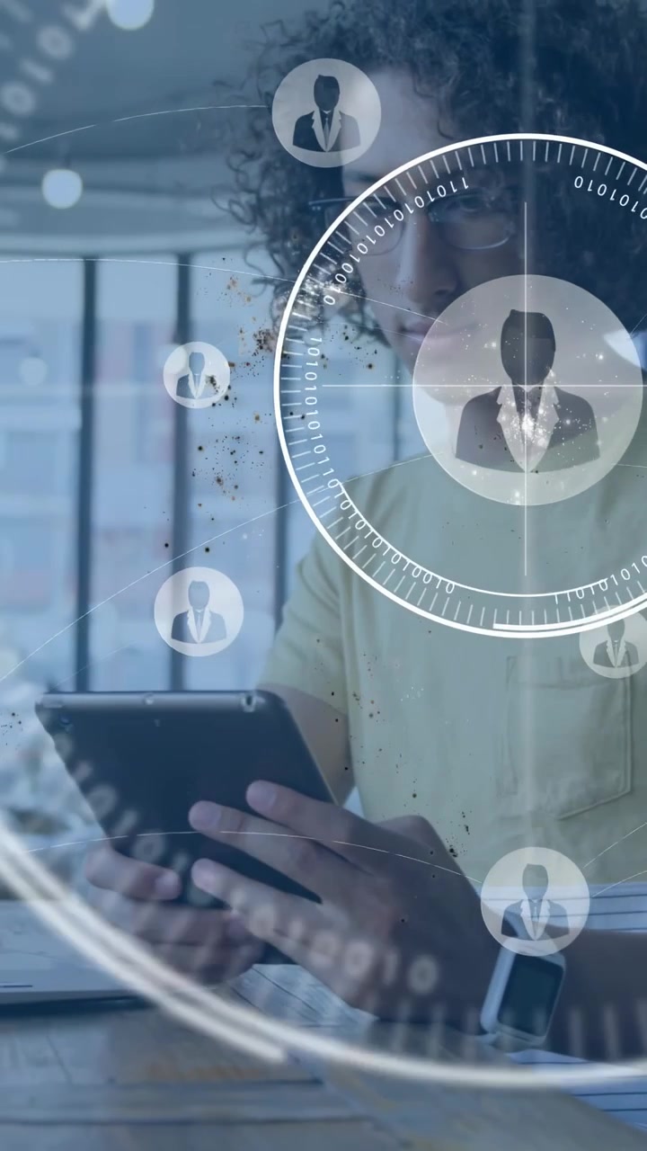 Vertical video: Man tapping phone then switching to tablet in office, HUD avatars mapping tech data