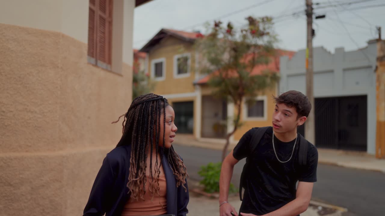 Two young people walking and talking on a street