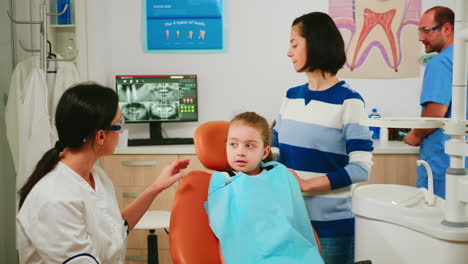 Médico-Mostrando-Al-Niño-La-Higiene-Dental-Correcta-Usando-Una-Maqueta-Del-Esqueleto-De-Los-Dientes