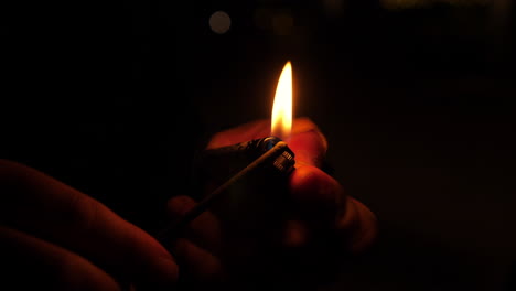 una persona encendiendo una chispa de fuegos artificiales con un encendedor, cerca