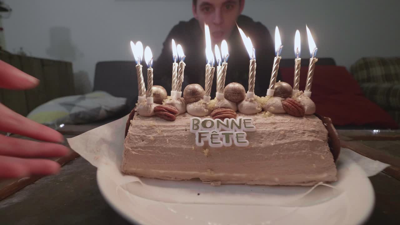 alguien llevando un pastel de cumpleaños para alguien más para soplar las velas