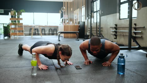 pareja haciendo flexiones en el gimnasio