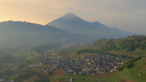 indonesian countryside with mount sindoro in the background