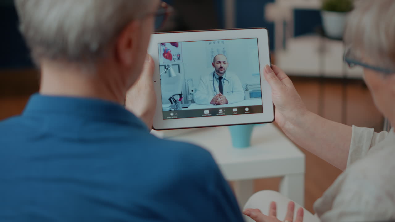 Elderly couple using tablet for telemedicine with doctor