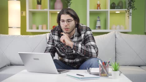 Young-man-working-at-home-alone-muttering-to-himself.