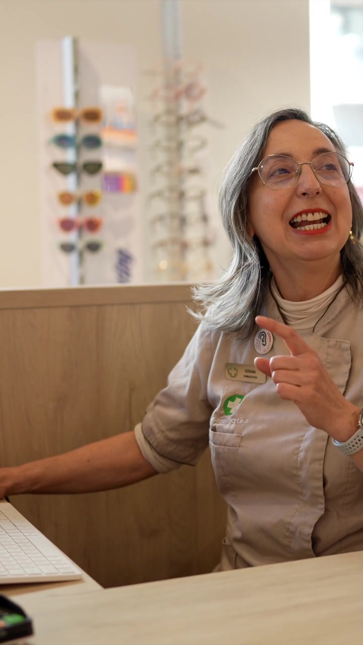 Optician Assisting Customer at Reception Desk in Optical Store