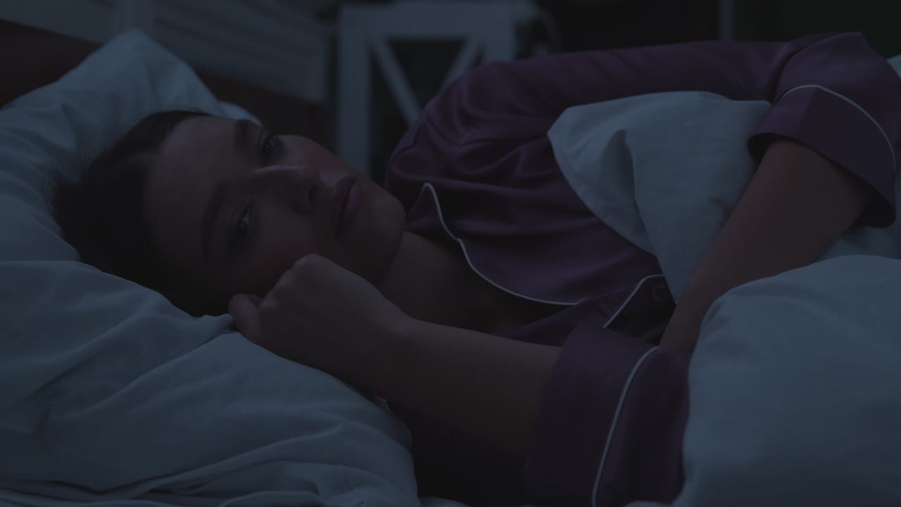 mujer acostada en la cama triste por la noche