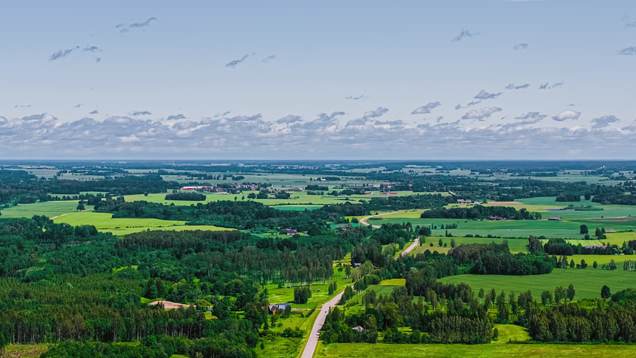 Aerial view of lush green landscape under cloudy sky, serene atmosphere