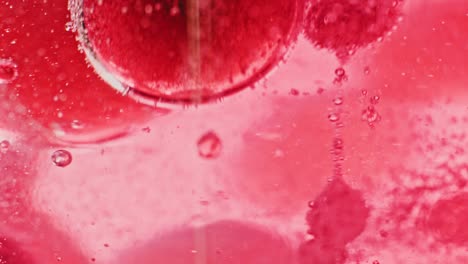 macro shot of big and small red bubbles floating and dripping in bright red water