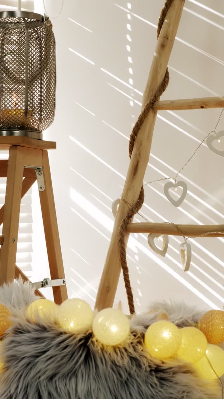 Slow pan captures dappled sunlight shifting across rustic ladder, heart garland and fairy-lit faux-fur cushion, creating warm boho interior vibe