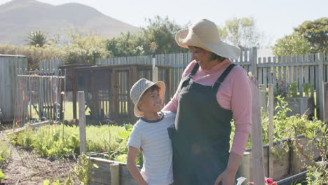 Retrato-De-Feliz-Abuela-Birracial-Y-Nieto-Abrazándose-En-El-Jardín,-Cámara-Lenta,-Espacio-De-Copia