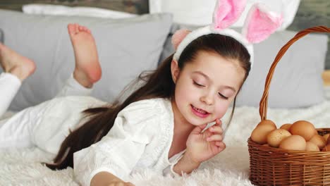 playful girl putting eggs in the easter basket