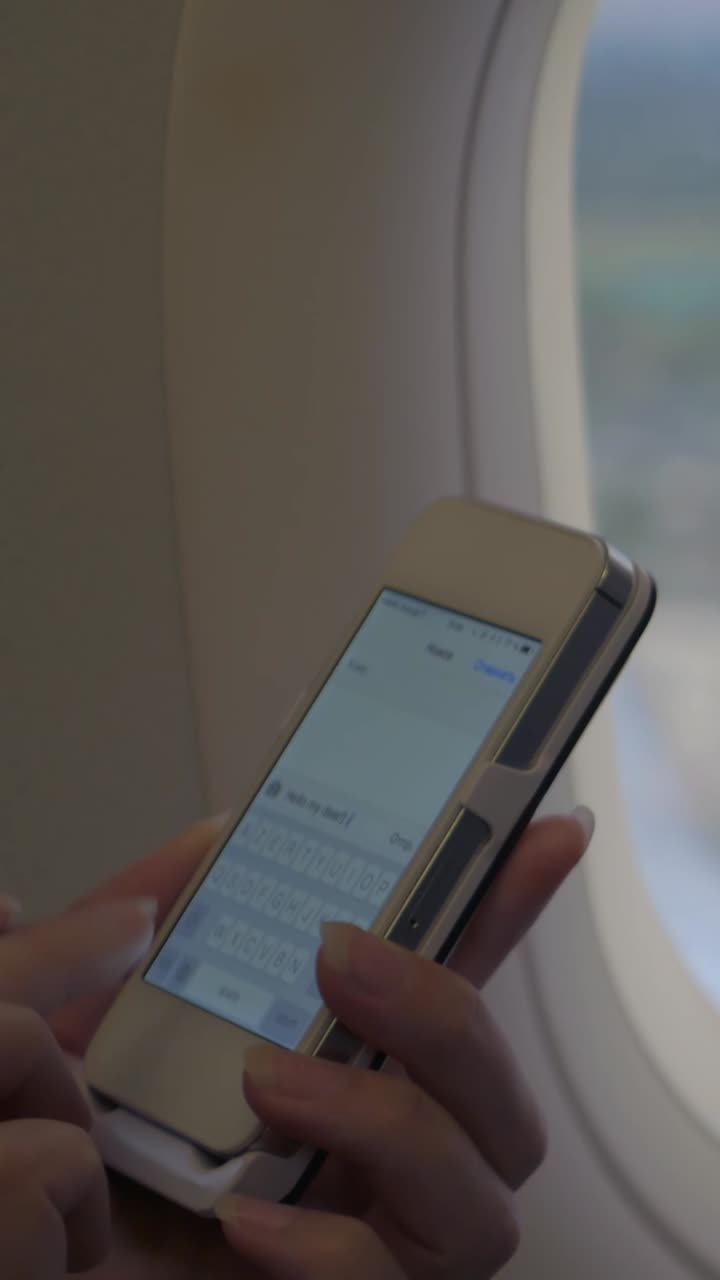 Close-up of Hands Typing on a Smartphone in an Airplane