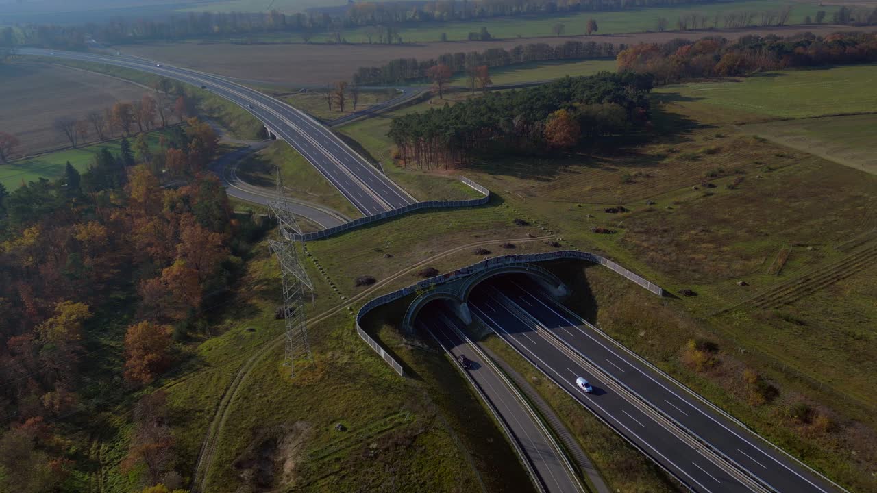 Ecoduct providing safe passage for wildlife over a german autobahn highway, seen from above. Tremendous aerial view flight drone shot from above