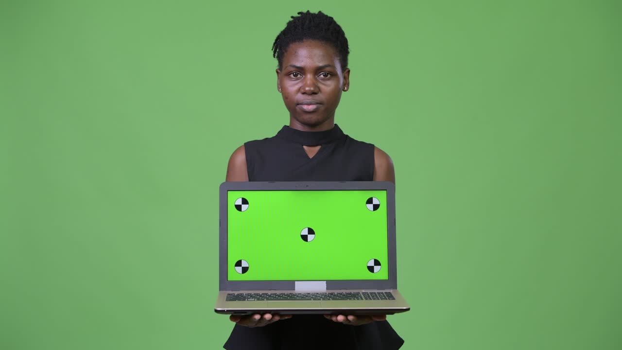 Young beautiful African businesswoman showing laptop