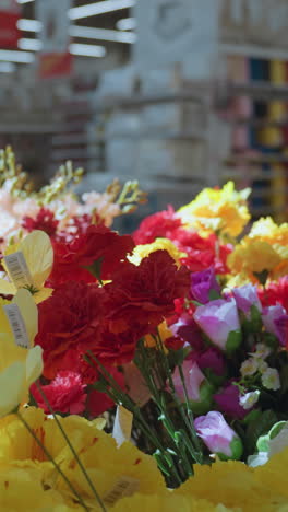 vista de una vibrante exhibición de flores de varios colores en un centro comercial. este video muestra la belleza y la diversidad de arreglos florales con un fondo borroso, mejorando el enfoque en las flores