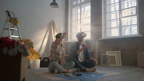 Serious-family-sitting-in-vr-glasses-on-floor.-Couple-making-project-in-3d.