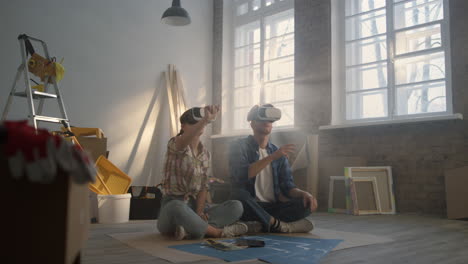 serious family sitting in vr glasses on floor. couple making project in 3d.