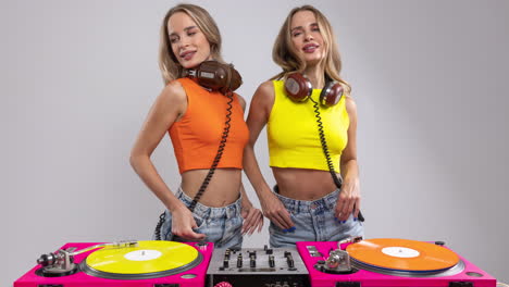 djs gemelas idénticas bailando detrás de los tocadiscos