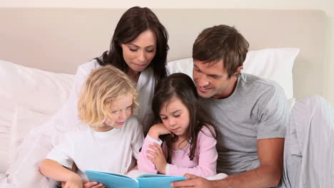 niños leyendo un libro con sus padres