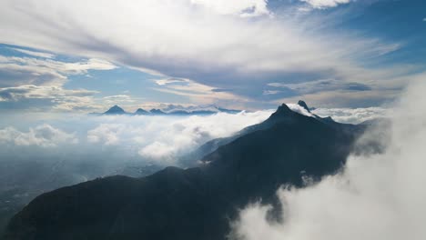 ascenso aéreo de la montaña toix en calpe, españa, con nubes que rodean los picos