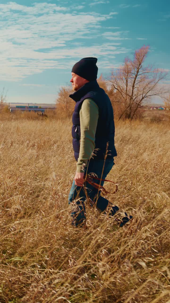 A serene connection between a person and their beloved dog as they stroll through a sunlit field, surrounded by tall grass and a vibrant blue sky, showcasing the calmness and joy of nature's companionship