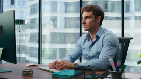 Focused-businessman-working-computer-in-office.-Serious-employee-typing-keyboard