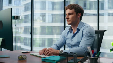 focused businessman working computer in office. serious employee typing keyboard