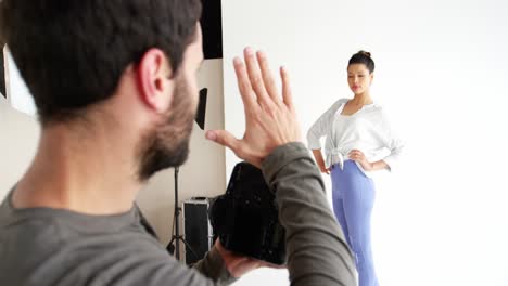 fotograf schießt mit weiblichem model während eines modeschusses