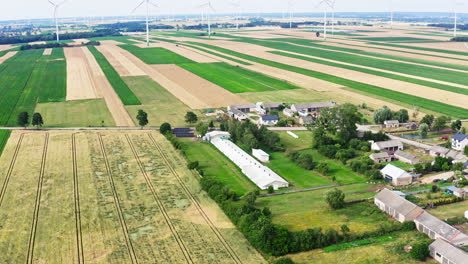 aerial view of fields, chicken farm, wind farm and village in poland. - pullback shot