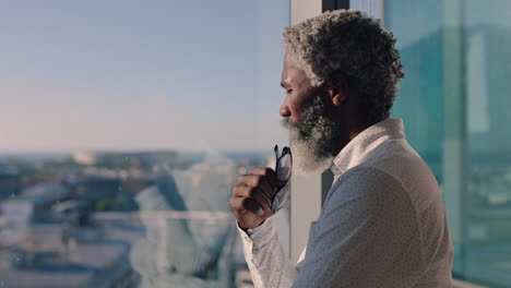 mature-african-american-businessman-looking-out-window-planning-ahead-thinking-of-ideas-for-future-business-development-with-view-of-city-at-sunset-4k