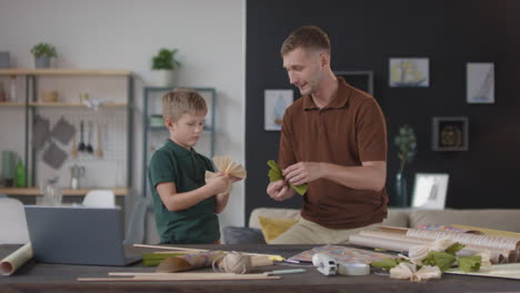 padre e hijo haciendo decoraciones de papel