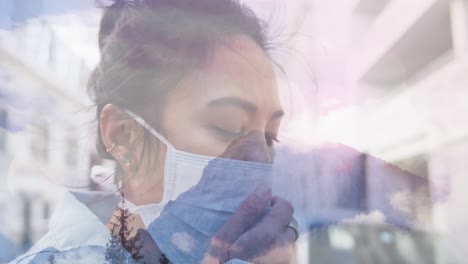 Animation-of-woman-wearing-face-mask-against-winter-scenery