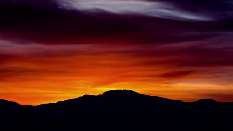 Tiro-De-Lapso-De-Tiempo-De-Hermoso-Amanecer-De-Color-Rojo-Detrás-De-La-Silueta-Del-Pico-De-La-Montaña