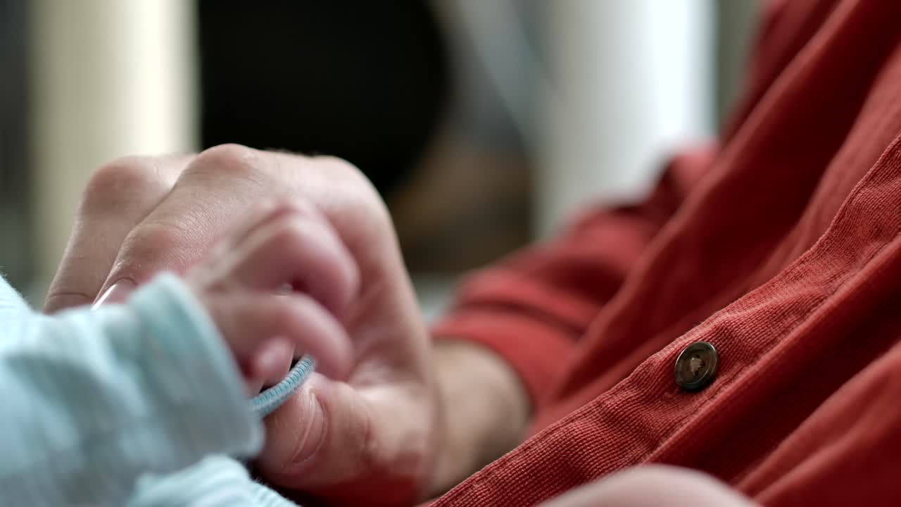 Father Holds Tiny Baby's Hands - Close Up Slow Motion