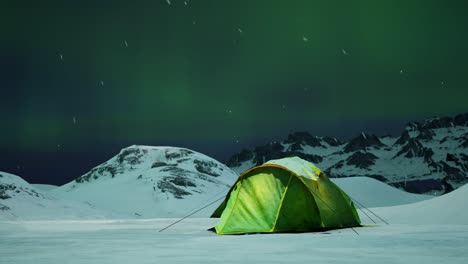 Green Tent Under Northern Lights in Snowy Mountains