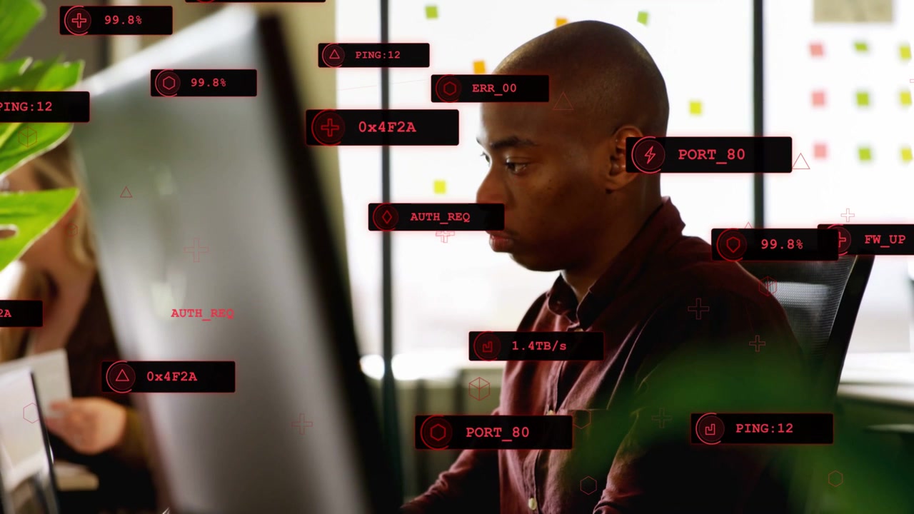 Man typing, camera shifting revealing profile, red HUD overlays around him analyzing network data