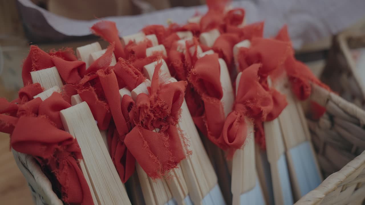Closeup of bamboo fans tied with red cloth in basket