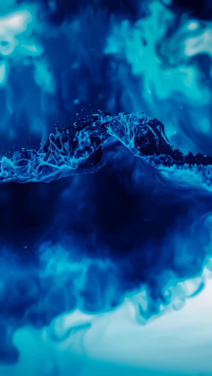 Video verticale: cresta di fluido blu in movimento che si sposta dopo l'impulso iniziale in macro dettaglio, mostrando l'orbita