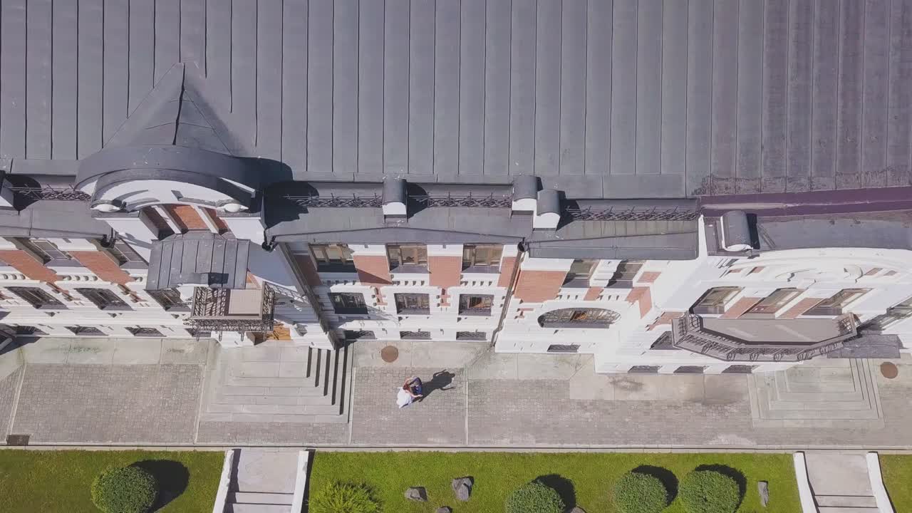 la sposa balla con lo sposo vicino all'edificio di abitazione vista superiore