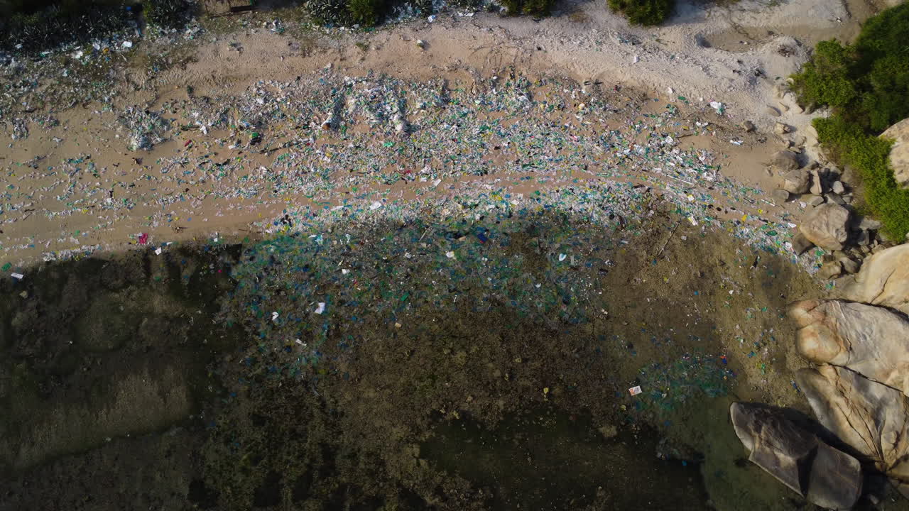 베트남 닌투언의 아름다운 관광 해변은 유색 플라스틱 쓰레기와 여전히 바다에 떠 있는 플라스틱 수프의 일부로 완전히 덮여 있습니다.