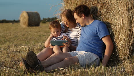 parents and son in countryside with pad