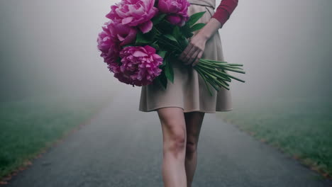 woman walking in fog with peonies