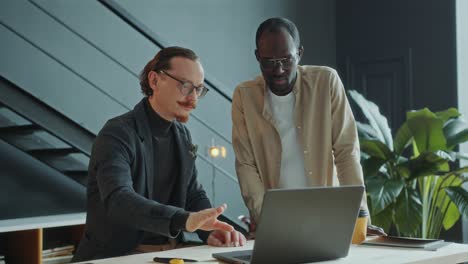 businessman discussing project on laptop with colleague in office