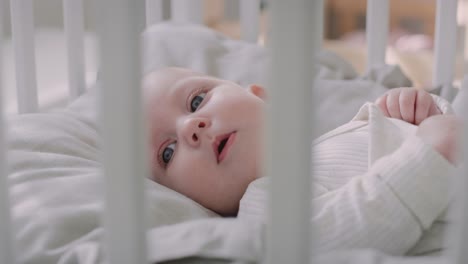 Neugeborenes-Liegt-Im-Kinderbett-Auf-Dem-Rücken-Und-Schaut-In-Die-Kamera
